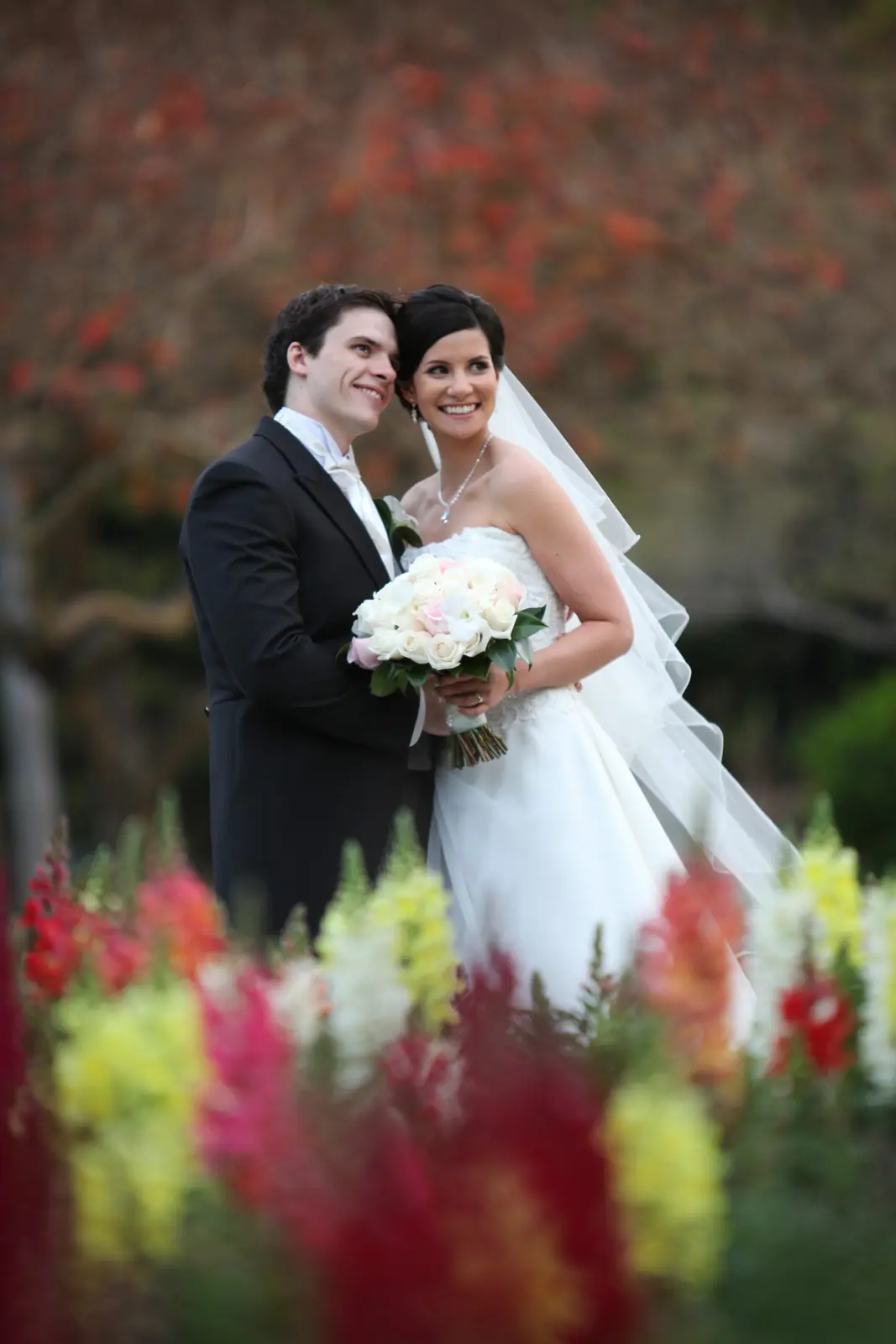 Lauren and Anthony kissing among flowers
