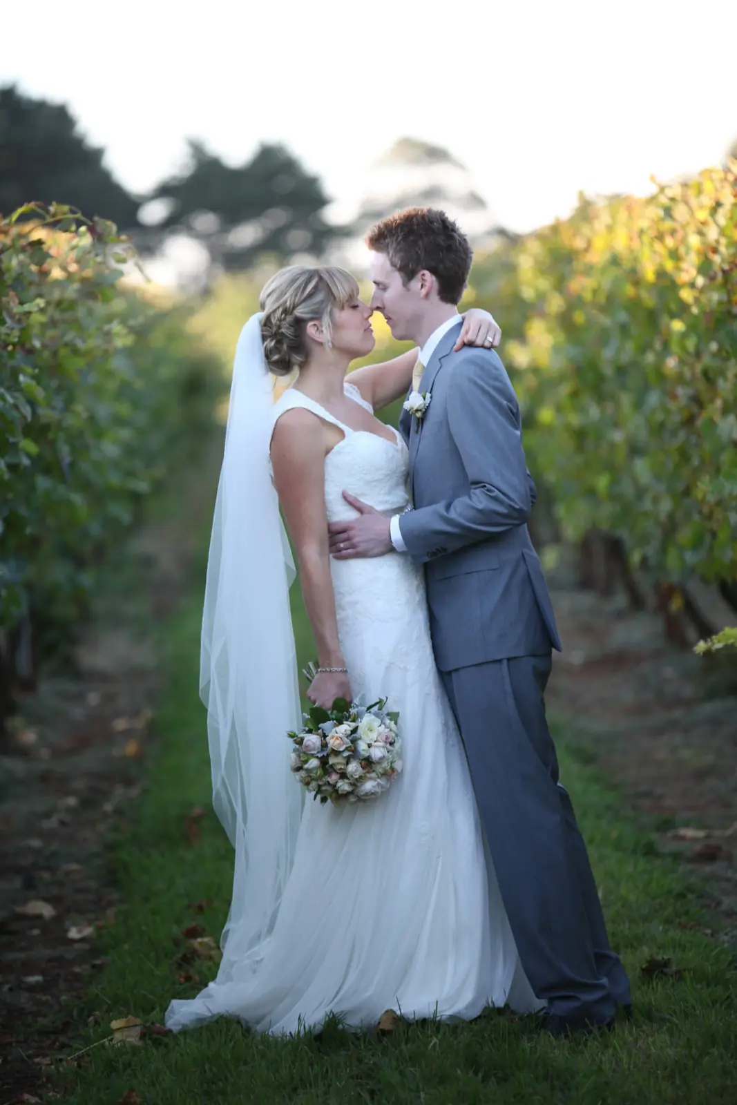 Lee and Michael kissing beneath a white arbour