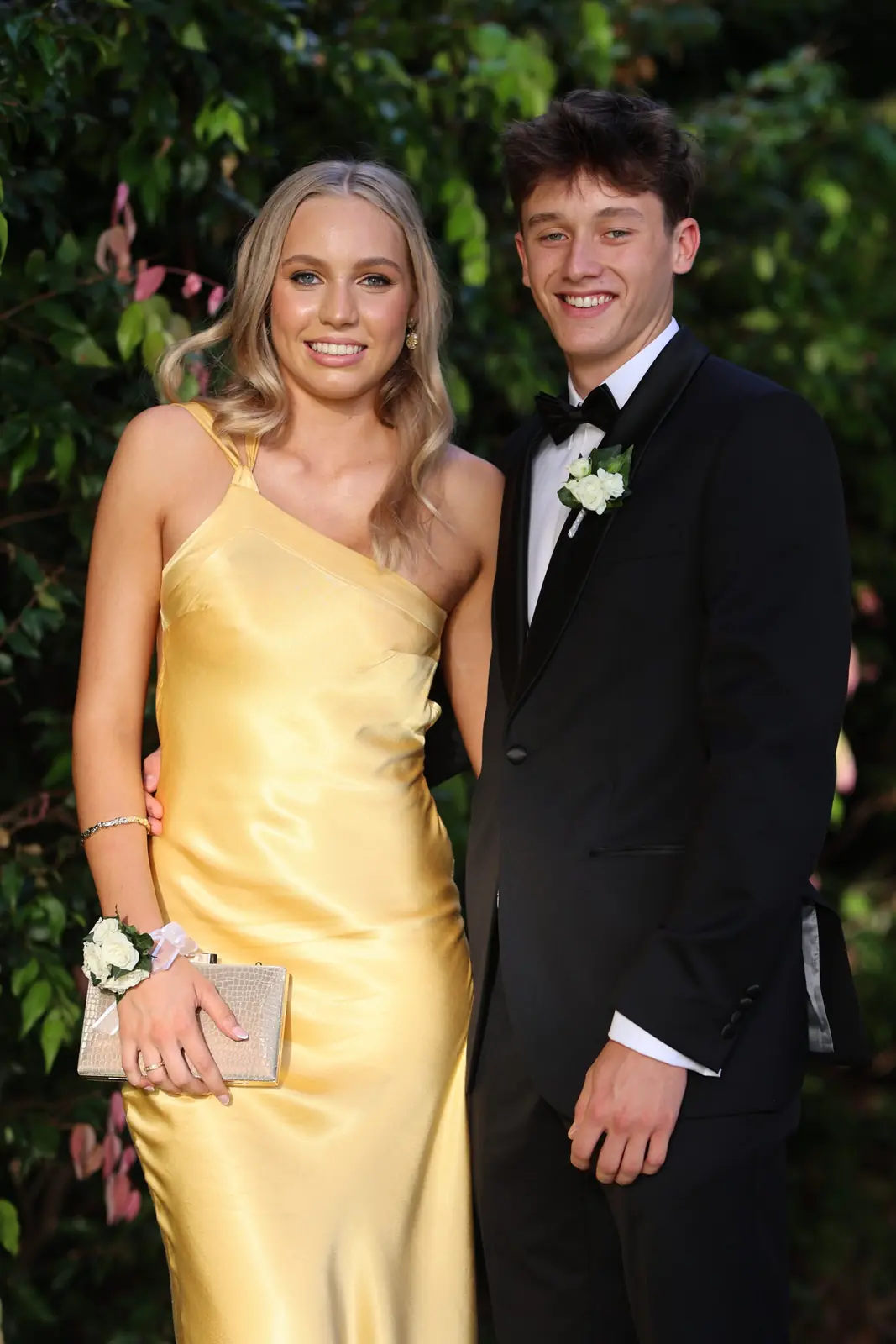 Formal couple in a gold gown and black tuxedo