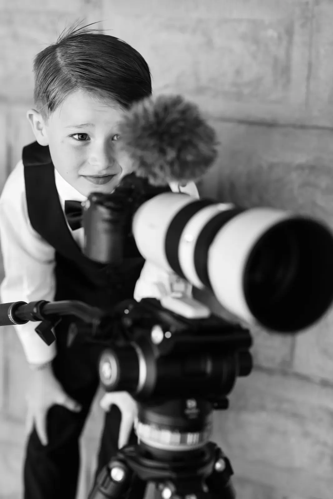 Young boy behind a camera at a wedding