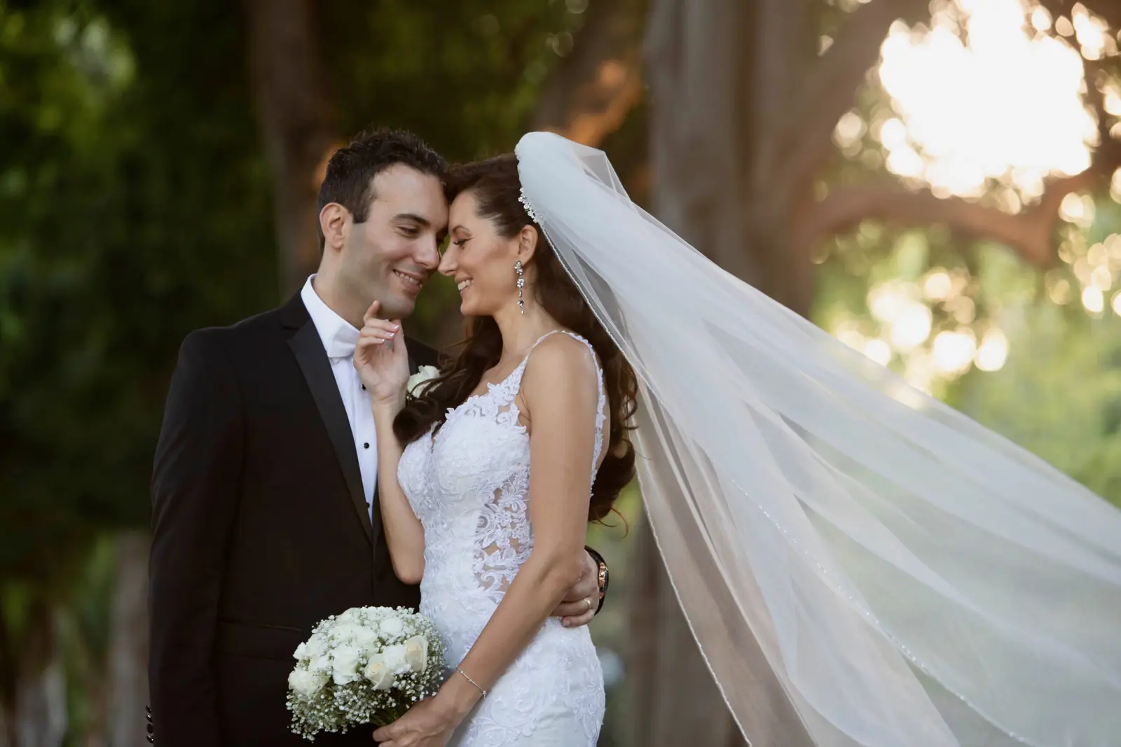 Couple wrapped in a wedding veil